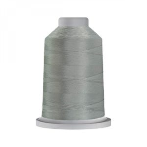 May include: A spool of light grey sewing thread featuring a cylindrical shape with a flat top and base. The thread is wound tightly around the central core, displaying a smooth, consistent texture and a subtle sheen across the entire surface.