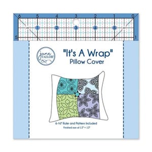 May include: A package for a pillow cover pattern, featuring a ruler at the top. The text reads "It's A Wrap Pillow Cover." The design includes a diagram of a pillow with floral patterns in teal, green, and purple. The finished size is 12" x 12".