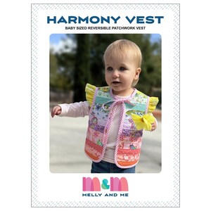May include: A baby-sized reversible patchwork vest with a colorful patchwork design. The vest has yellow ruffled sleeves and a pink bow. The image also includes the text "Harmony Vest" and the brand "Melly and Me".