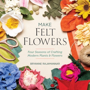 May include: A book titled "Make Felt Flowers: Four Seasons of Crafting Modern Plants & Flowers" by Bryanne Rajamannar. The cover features a variety of felt flowers in different colours and styles, including a pink lily, a white flower with a yellow centre, a blue hydrangea, a red poinsettia, and a yellow sunflower.
