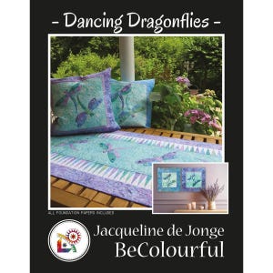 May include: A quilt pattern featuring a dragonfly design, with the text "Dancing Dragonflies." The image shows two throw pillows and a table runner with dragonfly motifs in shades of blue and purple. The pattern includes foundation papers.