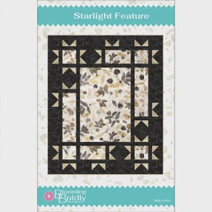 May include: A quilt pattern titled Starlight Feature by Blooming Boldly Designs, code BBD-0104. The design features a central rectangular panel with a botanical print of leaves and seeds, surrounded by a dark charcoal border with star motifs.