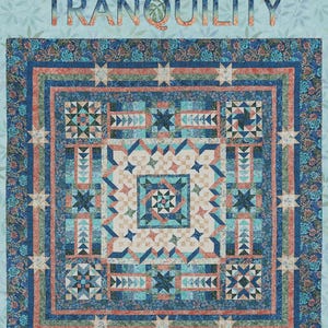 May include: A colorful quilt with the word "TRANQUILITY" across the top. The quilt features a central geometric design in shades of blue, teal, and peach, surrounded by patterned borders and star motifs. Finished size: 106" square.