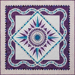 May include: A purple and blue quilt with a starburst design in the center. The quilt is surrounded by a border of purple and blue fabric with a wavy pattern.