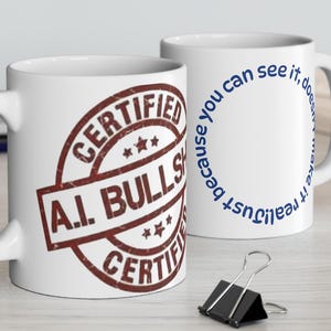 Könnte beinhalten: Zwei weiße Keramikbecher. Ein Becher zeigt ein braunes Stempeldesign mit dem Text "CERTIFIED A.I. BULLS** CERTIFIED". Der andere Becher hat den Text "...because you can see it, does not make it real".