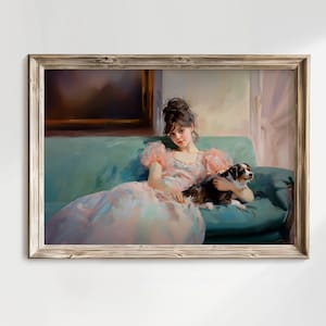 Pode incluir: Uma pintura de uma mulher com um vestido rosa sentada em um sofá turquesa com um cachorro pequeno. A mulher está olhando para o cachorro e o cachorro está olhando para a mulher. A pintura é emoldurada em uma moldura de madeira clara.