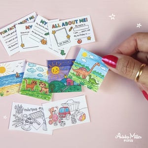 Miniature handmade school activity printables. Tiny 'All About Me' worksheets and colorful mini coloring pages with animals, dinosaurs, beach, and toys, displayed with a hand holding one card. Perfect dollhouse school supplies and miniature crafts by Aninka Miller Minis