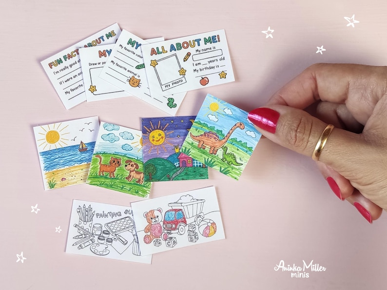 Miniature handmade school activity printables. Tiny 'All About Me' worksheets and colorful mini coloring pages with animals, dinosaurs, beach, and toys, displayed with a hand holding one card. Perfect dollhouse school supplies and miniature crafts by Aninka Miller Minis