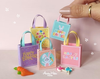 May include: Miniature Easter-themed tote bags in pastel colors, each with a different design. One bag is held by a hand. The bags feature images of a bunny, flowers, and the text "Happy Easter". A carrot and candies are also present.