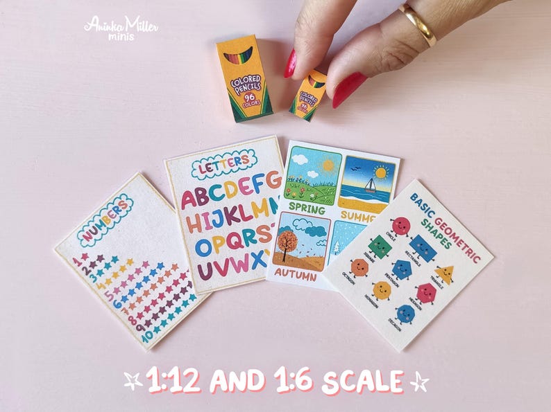 Miniature school printables and supplies in 1:12 and 1:6 scale. Tiny educational posters with alphabet letters, numbers, seasons, and geometric shapes, plus miniature colored pencil boxes, shown with a hand for scale. Perfect for dollhouse classrooms and miniature crafts by Aninka Miller Minis