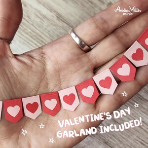 Miniature Valentines Day garland, handmade heart banner in red and pink, perfect for dollhouses, holiday decorations and crafts. Includes tiny heart-shaped flags for a festive, charming Valentine's Day look. Ideal for 1:12 or 1:6 scale dioramas