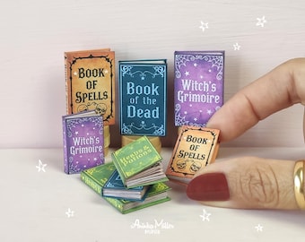 Può includere: Piccoli libri in miniatura con titoli come "Book of Spells" e "Witch's Grimoire". I libri sono in vari colori, tra cui arancione, blu e viola, con copertine decorative. Alcuni libri hanno illustrazioni di teschi e ragnatele.