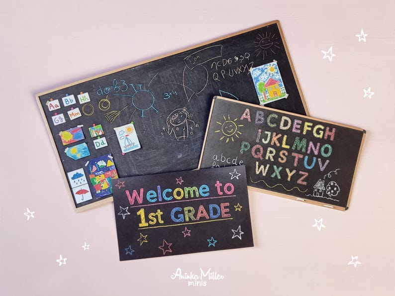 Miniature classroom chalkboards with colorful alphabet letters, drawings, and 'Welcome to 1st Grade' sign, perfect for dollhouse school scenes, teacher gifts, or educational crafts, displayed on a light pink background. By Aninka Miller Minis