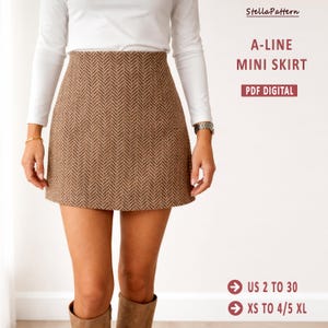 Puede incluir: Minifalda A-line marrón con estampado de espiga, combinada con una camiseta blanca de manga larga. La imagen incluye el texto "A-LINE MINI SKIRT" y "PDF DIGITAL". Tallas US 2 a 30 y XS a 4/5 XL.