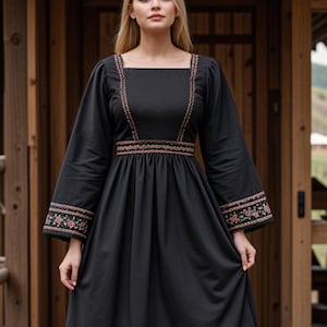 Puede incluir: Un vestido negro maxi con mangas largas y escote cuadrado. El vestido presenta detalles florales bordados en rosa y marrón a lo largo del escote, las mangas y el dobladillo.