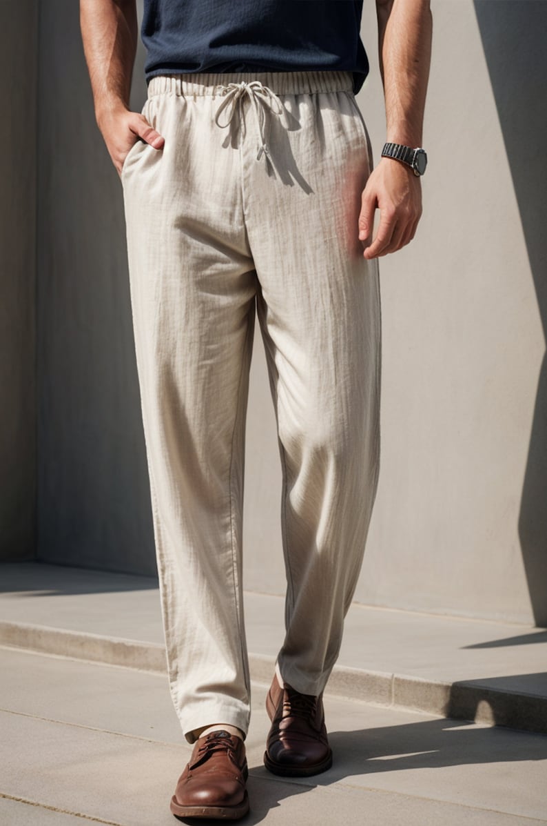 Peut inclure: Pantalon en lin beige avec une taille &agrave; cordon et une coupe d&eacute;contract&eacute;e. Le pantalon est pr&eacute;sent&eacute; sur un mannequin portant des chaussures en cuir marron.