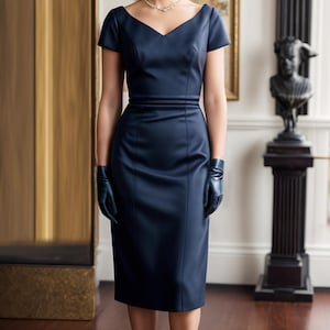 Peut inclure: Une femme portant une robe bleu marine &agrave; la silhouette ajust&eacute;e et aux manches courtes. Elle porte un petit chapeau bleu marine et des gants noirs. La robe a un d&eacute;collet&eacute; en V et un petit n&oelig;ud &agrave; la taille.