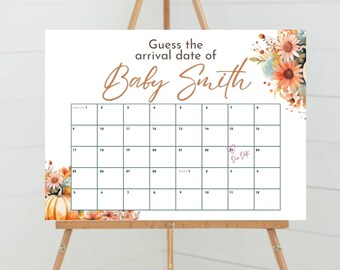 May include: A white sign on a wooden easel with the text "Guess the arrival date of Baby Smith." A calendar grid is printed on the sign, with floral and pumpkin accents. A date is marked with a pen.
