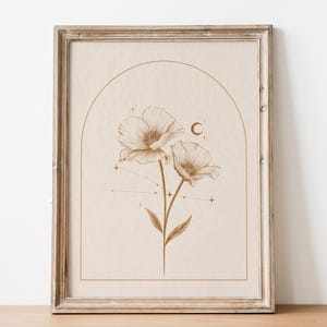May include: A framed print featuring a botanical illustration of two flowers with a celestial design. The artwork is in shades of brown and beige, with a crescent moon and star accents. The frame is made of distressed wood.