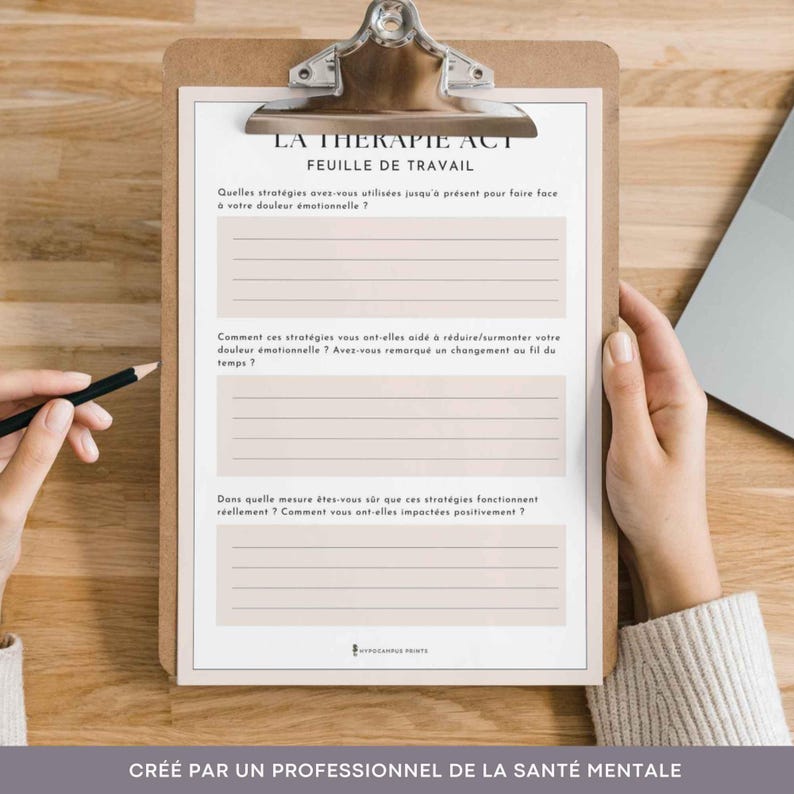 K&ouml;nnte beinhalten: Ein Arbeitsblatt mit dem Titel "La Therapie ACT Feuille de Travail" mit Fragen zu emotionalem Schmerz und Bew&auml;ltigungsstrategien. Das Arbeitsblatt befindet sich auf einer Klemmbrett mit einer Hand, die einen Bleistift h&auml;lt.