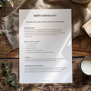 Könnte beinhalten: Ein weißes Dokument mit dem Titel "BOÎTE À OUTILS ACT" auf einer Holzoberfläche. Das Dokument enthält Text auf Französisch, einschließlich einer Einführung, der Zielgruppe und der Voraussetzungen für die Werkzeuge. Eine Tasse und ein Buch sind sichtbar.