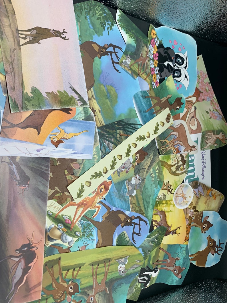 May include: A collection of colorful, illustrated cards featuring Bambi, the Disney character, in various scenes from the movie. The cards are cut out and arranged in a random pattern, creating a whimsical collage.