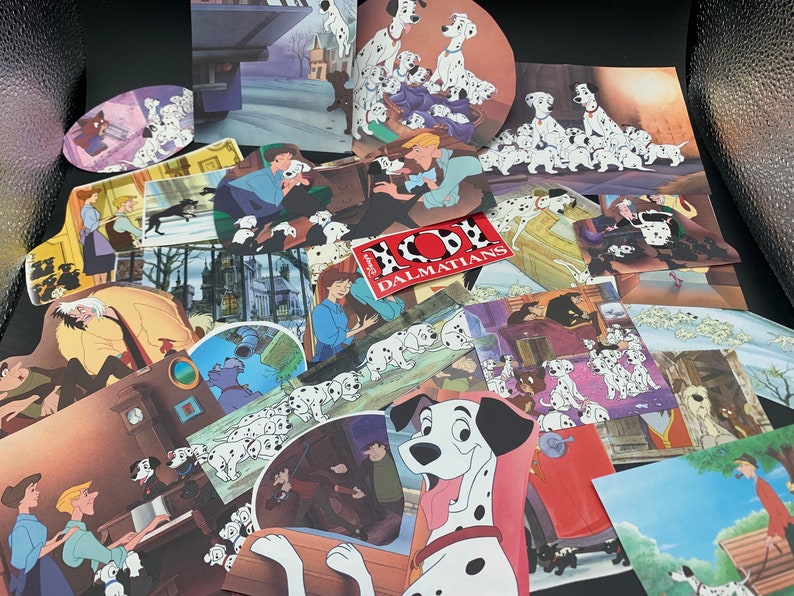 May include: A collection of 101 Dalmatians themed paper cutouts featuring various scenes from the movie. The cutouts include images of Dalmatian puppies, the villain Cruella De Vil, and the iconic "101 Dalmatians" logo.