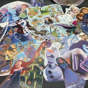 May include: A collection of colorful stickers featuring characters from the animated film Frozen. The stickers include images of Elsa, Anna, Olaf, Kristoff, Sven, and other characters from the movie. The stickers are perfect for decorating notebooks, laptops, water bottles, and other items.