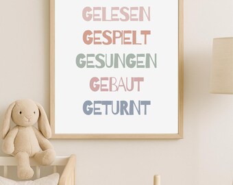 May include: A framed print with the German text "HIER WIRD GELESEN GESPIELT GESUNGEN GEBAUT GETURNT" in pastel colors. A stuffed bunny and a wooden stacking toy are in the foreground, suggesting a nursery or playroom setting.