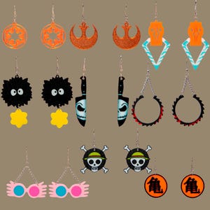 Puede incluir: Un conjunto de 10 pares de pendientes con diversos temas de la cultura popular y la fantasía. Los pendientes están hechos de madera y tienen una variedad de colores y diseños, incluyendo una calavera y huesos cruzados, un símbolo de Star Wars, un personaje de Totoro y un cuchillo.