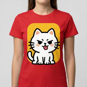 May include: Red t-shirt with a cartoon cat graphic. The white cat has a grumpy expression with its tongue out, set on a yellow background. The t-shirt is a plain red colour.