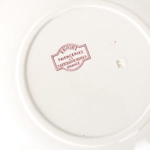 Puede incluir: Un plato de cer&aacute;mica blanco con un sello rojo que dice "FAVORI FAIENCERIES DE SARREGUEMINES FRANCE". El plato tiene un dise&ntilde;o circular con un borde elevado.