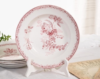 May include: Set of four vintage white ceramic soup bowls with a pink and red floral pattern. The bowls have a scalloped edge and a delicate floral design.