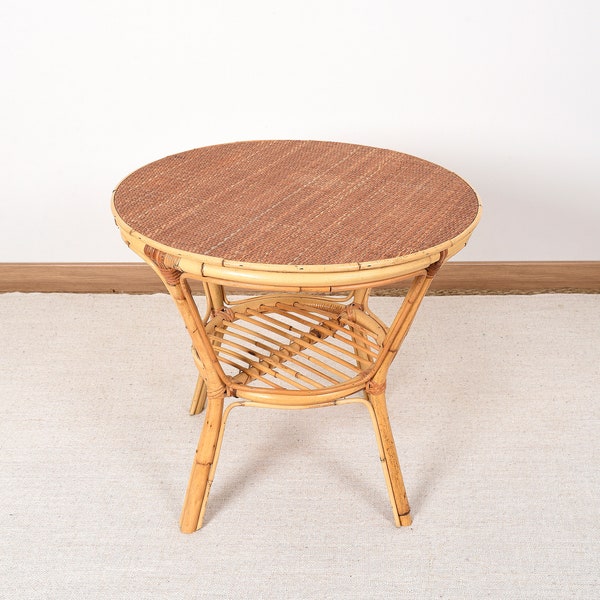 Table ronde en rotin ancienne, vintage des années 70 - 80. Petite table, ou table d'appoint, décoration intérieure de style rétro, tendance.