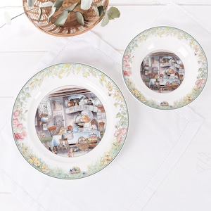 May include: White ceramic mug with a black handle, featuring the text "But First, Coffee" in black. The mug is displayed against a blurred backdrop, implying a comfortable environment.