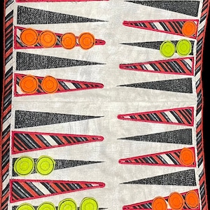 May include: A white fabric backgammon board with red and black striped triangles. The board has orange and yellow counters.