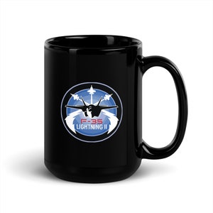 May include: Black ceramic mug with a white graphic of an F-35 Lightning II fighter jet in a circle with a blue background. The text "F-35 Lightning II" is written in red and white.