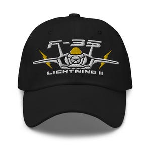 May include: Black baseball cap with an embroidered F-35 Lightning II logo in white and yellow.