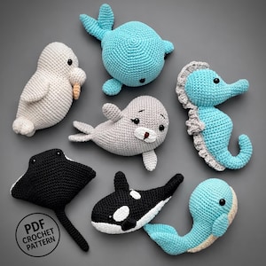 May include: A collection of handmade crochet sea creatures, including a white seal, a gray seal, a blue whale, a blue seahorse, a black and white orca, a black stingray, and a blue whale. The text "PDF Crochet Pattern" is visible.