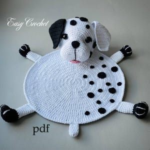 Può includere: Tappeto all'uncinetto a forma di cane dalmata. Il tappeto è bianco con macchie e dettagli neri, tra cui orecchie, zampe e naso. Il testo "Easy Crochet" e "pdf" sono visibili.