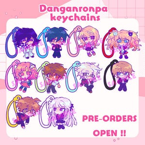 Op de afbeelding: Een verzameling van tien Danganronpa-personage sleutelhangers met kleurrijke lussen, met diverse figuren in anime-stijl. De afbeelding bevat de tekst Danganronpa keychains en PRE-ORDERS OPEN !! in een roze en wit grafisch ontwerp.