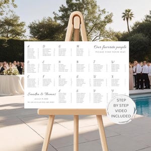 May include: A white seating chart with names, displayed on a wooden easel. The chart includes the text "Our favorite people, Please find your seat." The names are organized alphabetically. The date and names of the couple are also included.