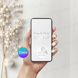 May include: A smartphone mockup held in a hand, featuring the text "Drag & Drop MOCKUP" and a sticker that says "3 MOCKUPS INCLUDED". A Canva logo is visible. White flowers and foliage are in the background.
