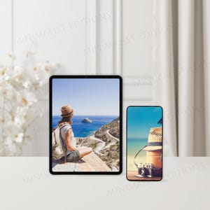 Op de afbeelding: Een tablet en smartphone tonen pittoreske reisfoto's. De tablet toont een persoon die uitkijkt over een kustlandschap. De smartphone toont een strandsc&egrave;ne met een hoed en camera. De achtergrond heeft een witte tafel en gordijnen.