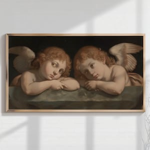 May include: A framed painting featuring two cherubic figures with reddish-blonde hair and feathered wings. The figures are depicted in a classical style, resting their heads on a stone surface. The artwork is set against a dark background.