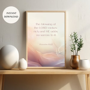 May include: A printable wall art design with a quote from Proverbs 10:22, "The blessing of the LORD makes rich, and HE adds no sorrow to it." The background is a soft, abstract design with pink, purple, and orange hues.