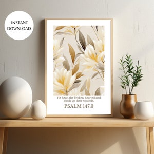 Pode incluir: Uma impressão de arte de parede bege imprimível com um design floral e o texto "Ele cura os quebrantados de coração e enfaixa suas feridas. SALMO 147:3"