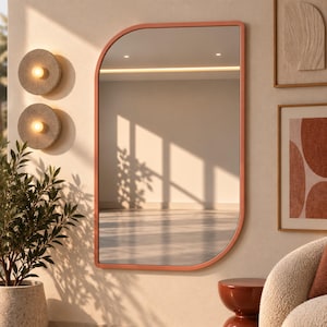 Peut inclure: Un miroir mural doté d'un cadre couleur terre cuite avec une forme asymétrique unique, caractérisée par un coin supérieur arrondi et un coin inférieur incurvé, reflétant un espace intérieur lumineux avec lumière naturelle et ombres.