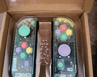 Joy-Con trasparenti sfumati blu-verdi con pulsanti arcobaleno pastello