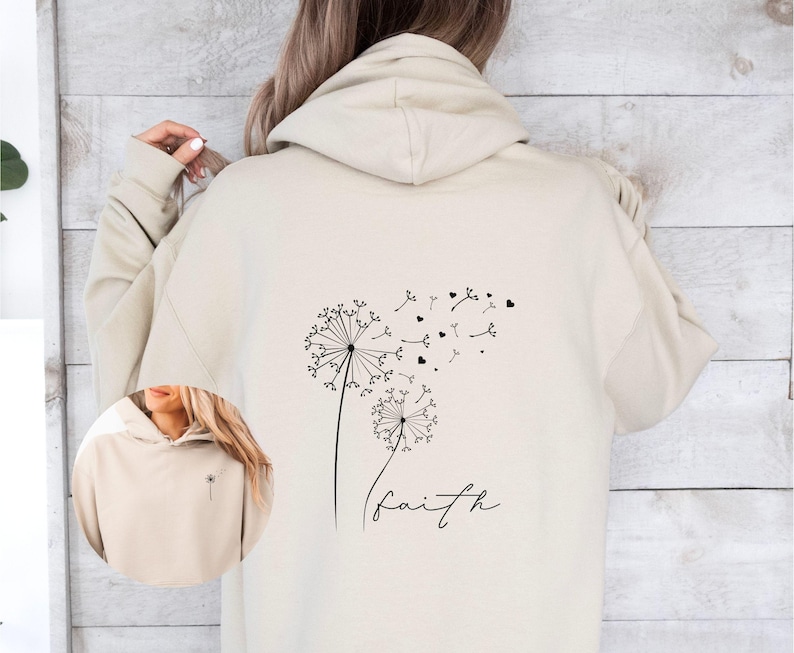 Pu&ograve; includere: Una felpa con cappuccio beige con un disegno di dente di leone nero e la parola "faith" stampata sul retro.